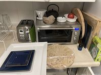 Overview showing toaster oven, Cuisinart toaster, teapot, plates, filter cone, racks