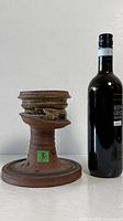 Full view of pedestal cup beside wine bottle for scale