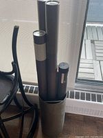 Metal container with five mailing tubes inside