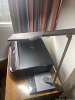 Printer and desk lamp on table, overall view