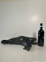 Full view of entire soapstone seal next to bottle for scale