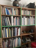 Front view of both wooden bookshelves filled with books and decor showing overall design, color, and condition