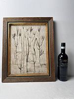 Framed painting beside wine bottle for scale