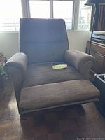 Front view of brown fabric electric recliner with remote on seat