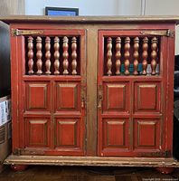 Front view of red wooden cabinet with doors closed