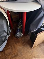 Full view of white round tabletop and red legs