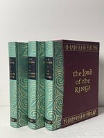 Three teal cloth volumes in decorative slipcase front view