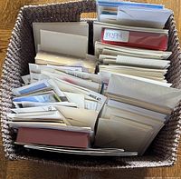 Woven basket filled with stacked greeting cards and postcards