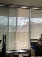 Full view of three white curtains covering windows