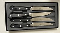 Open box showing four Wusthof steak knives with triple-riveted handles