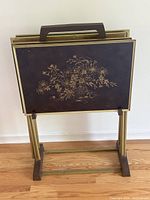 Front view of stacked TV trays on stand showing floral design