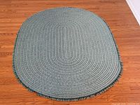Full view of oval braided rug on floor