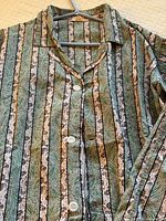 Front view of pajama top on hanger showing buttons, collar and stripe pattern