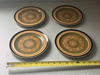 Set of four matching luncheon plates with tape measure showing 7.5 in diameter