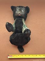 Full view of tartan-clad stuffed Scottie beside ruler showing length