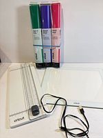 Lot overview showing trimmer, light pad, three vinyl rolls and cable