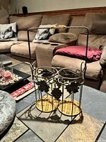 Dual wine bottle caddy, wrought iron with wicker bases and grape-leaf accents