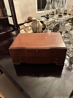 Closed walnut cutlery chest on table