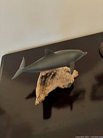 Side view of dolphin sculpture on driftwood