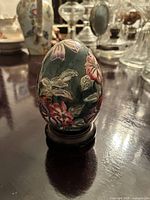 Dark green floral porcelain egg on stand