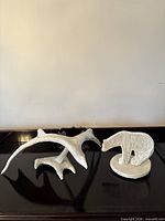 Both sculptures side by side on surface