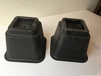 Two black plastic square risers side view