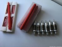 Group view of three packages of red tapers and six silver tapers