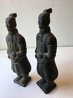 Front three-quarter view of both statuettes showing overall form and condition