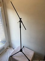 Full view of microphone stand fully assembled showing boom arm, main tube and tripod base