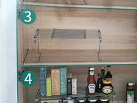 Product usage photo depicting silver expandable wire shelf inside cabinet