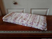 Blanket folded on table with ruler for scale