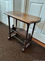 Full view of side table showing top, legs and lower shelf