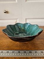 Top angled view showing scalloped rim, glaze, and exterior color contrast with ruler for scale