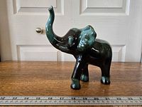 Left-front view of full figurine with ruler for scale