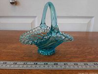 Side view showing ruffled rim, applied handle and pedestal base next to ruler