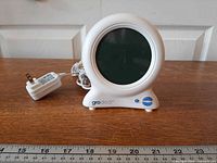 Front view of Gro-Clock with power adapter and ruler for scale