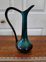 Front view of Blue Mountain Pottery green/black drip glaze pitcher