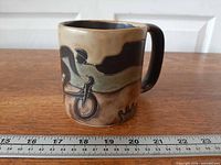 Mug side view with bicyclist design, ruler for scale