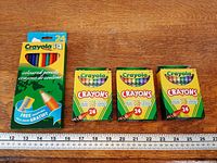 All four Crayola boxes aligned beside ruler for scale