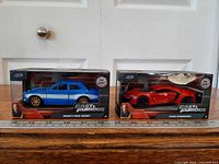 Both boxed cars side by side with ruler for scale