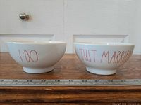 Two footed bowls side by side showing exterior text
