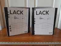 Both sealed IKEA Lack shelf packages front view