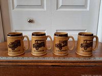 Front view of all four Wade tankards in a row