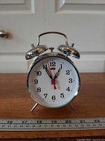 Front view of alarm clock showing full dial and metal housing