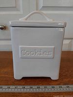 front view of square white ceramic canister with Cookies panel and lid