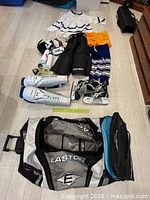 Full layout of all equipment showing skates, pads, jerseys, bag and accessories