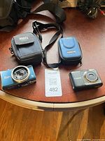 Full lot view showing two Canon cameras and two cases with lot tag