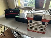 Plano tackle box, Fenwick organizer, Jobmate bag on table
