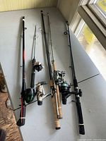 All five rods laid out on table showing overall variety and attached reels