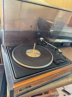 Top view with dust cover open showing platter, tonearm, controls and spindle